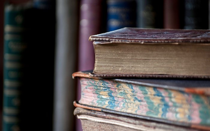Stack of old books with marbled pages