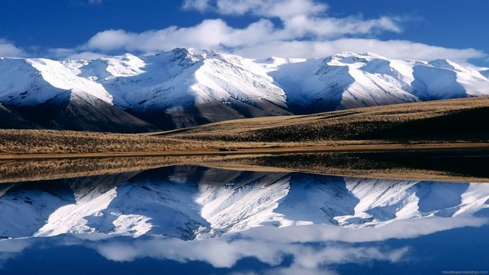 Snow-capped mountains reflected in a calm lake