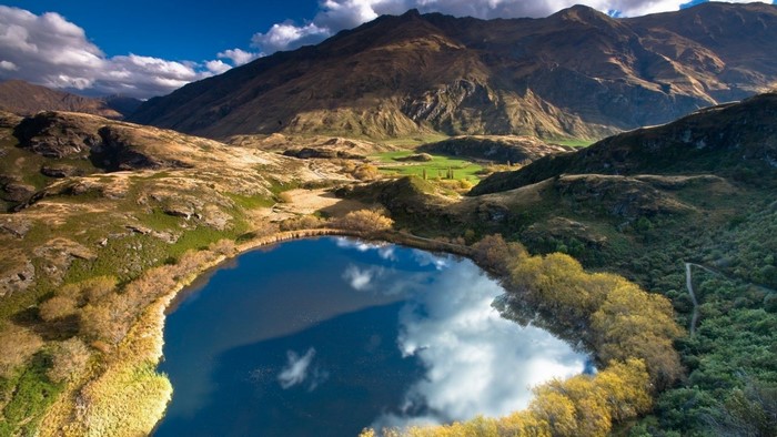 Aerial view of a lake surrounded by mountains and hills
