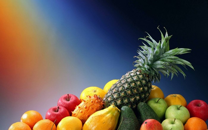 Assortment of fresh fruits including pineapple, apples, and oranges