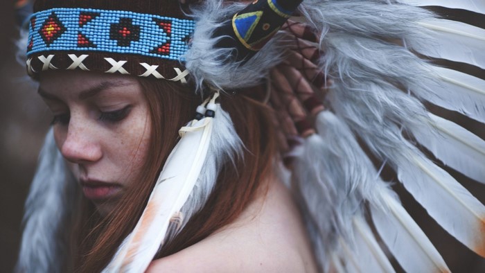 Woman with red hair and feathered headdress