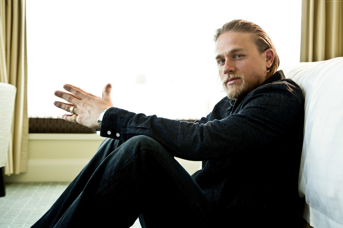 Charlie Hunnam sitting indoors