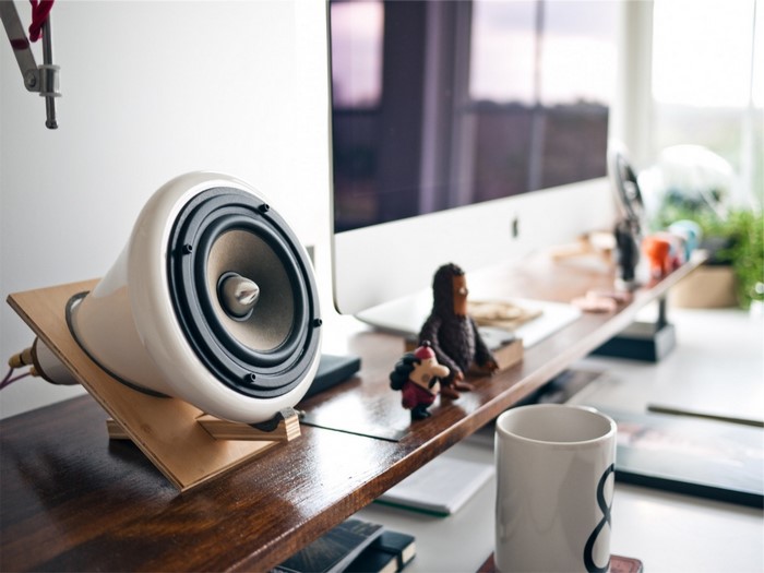 Speaker on a desk with iMac and figurines