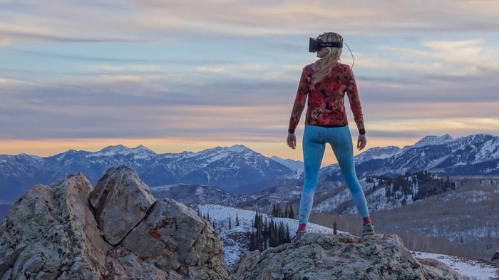 Woman wearing VR headset on mountain peak