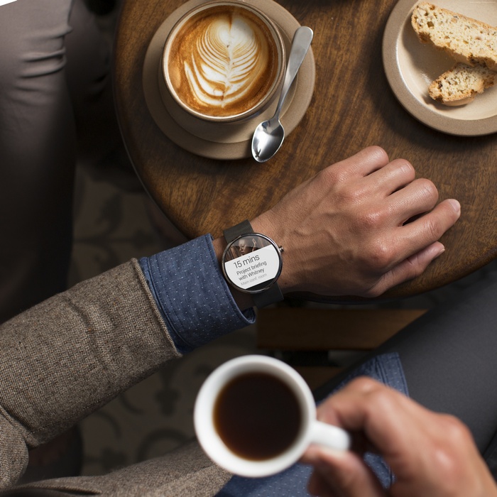 Man wearing Moto 360 smartwatch at cafe