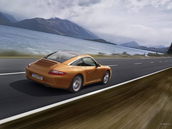 Orange Porsche 911 Targa driving on a road