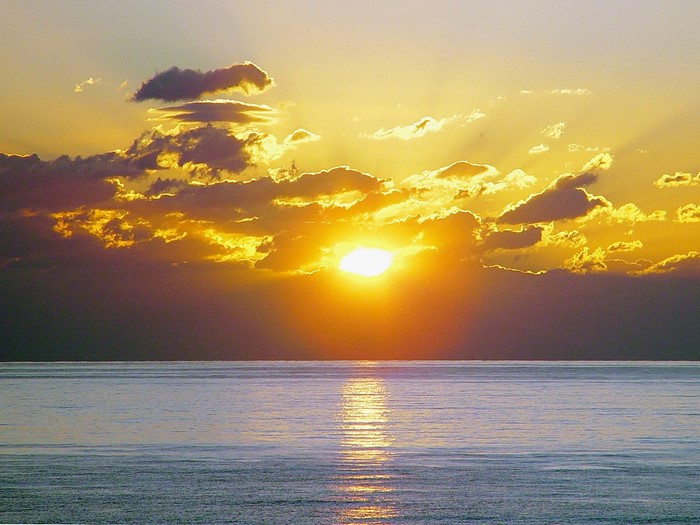 Sunset over the ocean with dramatic clouds