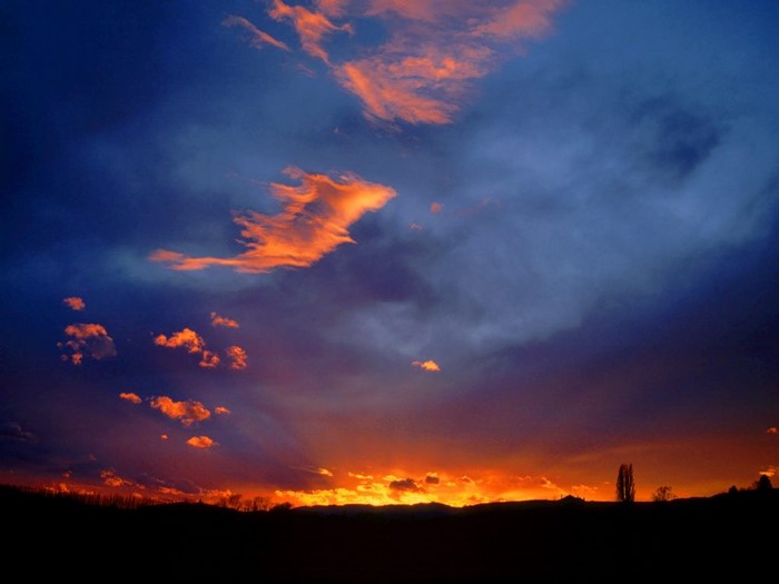 Sunset with orange clouds over a dark horizon