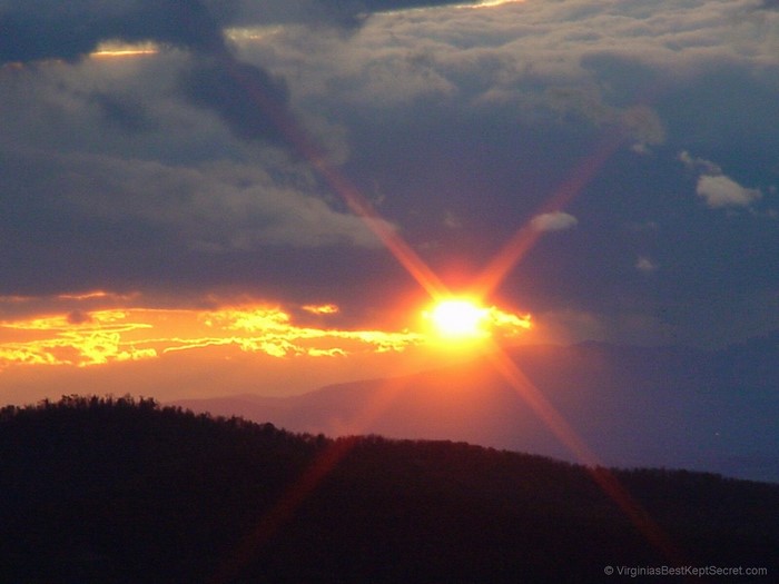 Sunset over mountains with sunburst