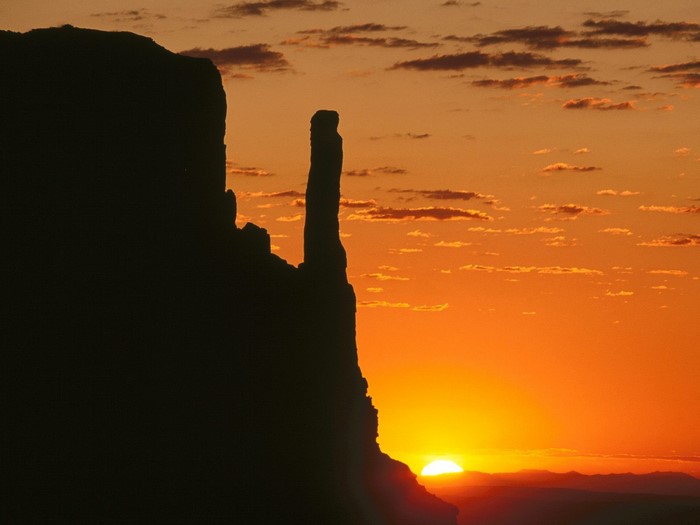 Silhouette of rock formations against a sunset sky