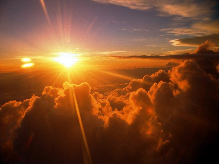 Sunset over clouds with sun rays
