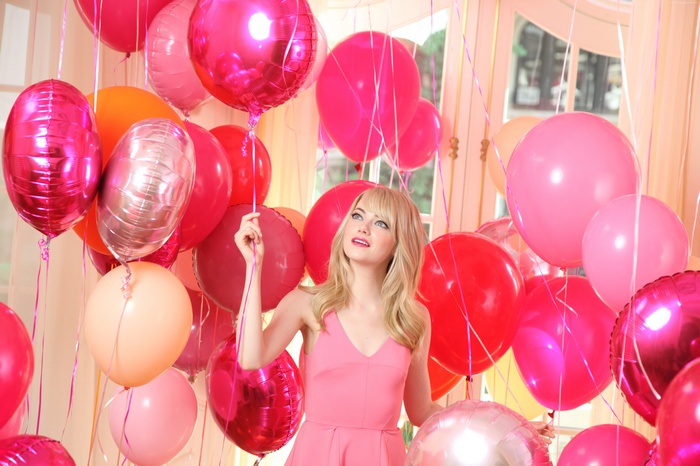Emma Stone surrounded by pink and red balloons