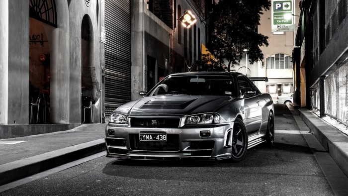 Nissan Skyline GT-R R34 parked on a city street at night