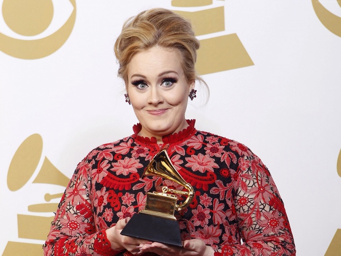 Adele holding a Grammy award