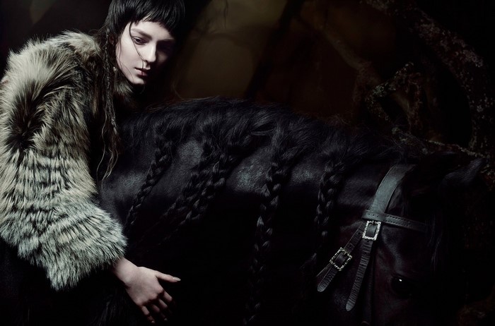 Woman in fur coat with black horse