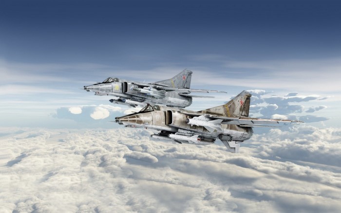 Two Mikoyan MiG-27 fighter jets flying above clouds