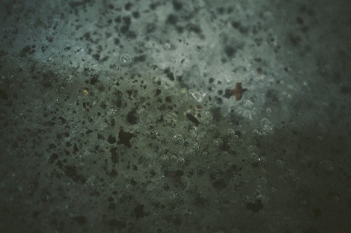 Macro photography of ice texture with bubbles and dark particles