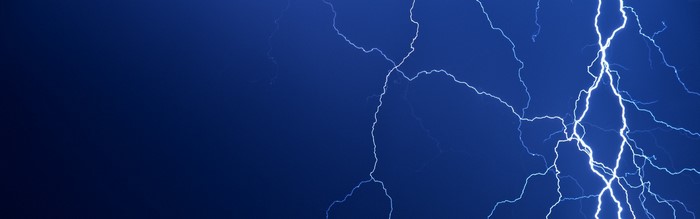 Lightning strikes across a dark blue sky
