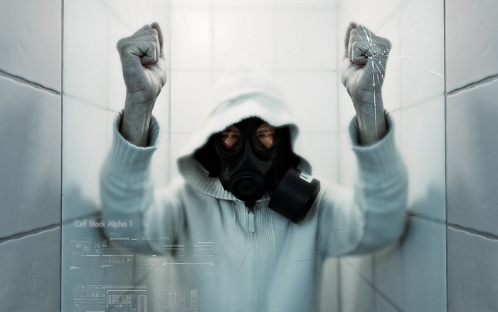 Person in gas mask and hoodie with fists raised