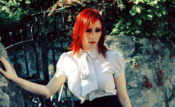 Redhead woman in white top and black skirt
