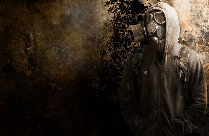 Man in gas mask and hoodie with backpack