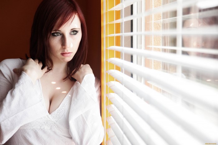 Woman with red hair looking out window