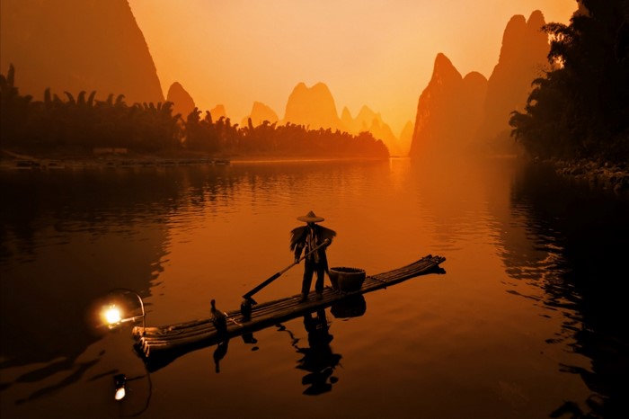 Fisherman on a raft on the Li River at sunset