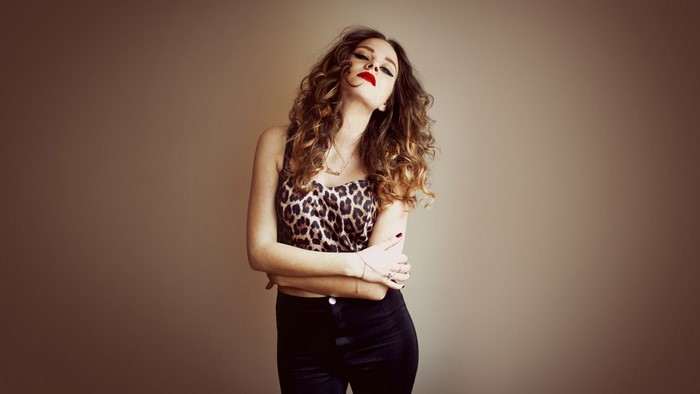 Kasia Lins portrait with curly hair and leopard print top