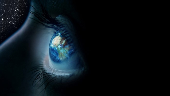 Earth reflected in a human eye with stars