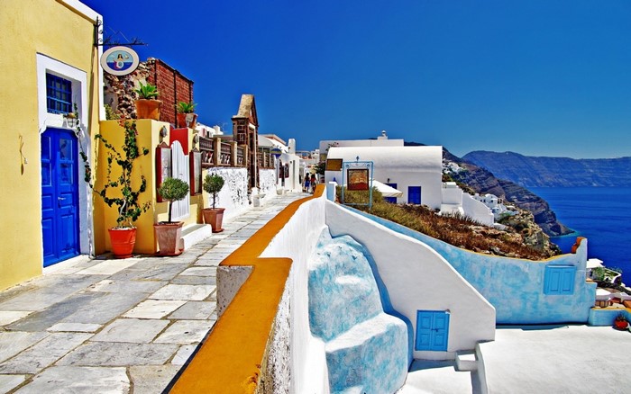 Santorini, Greece: A picturesque street with blue doors and sea views