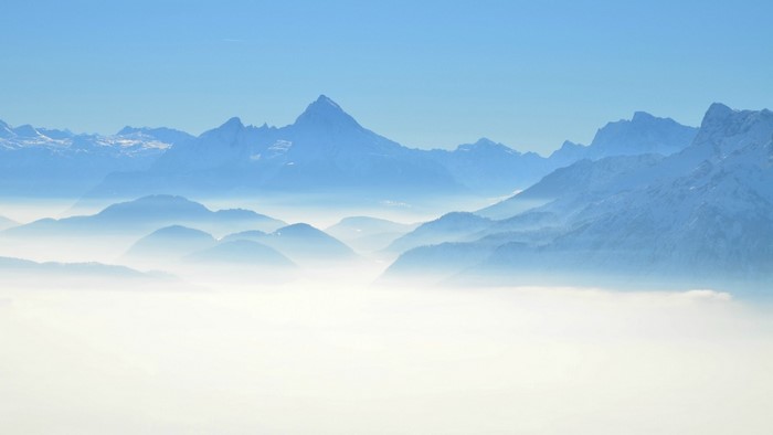 Misty mountains under a clear blue sky