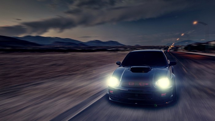Subaru Impreza WRX STi driving on a desert road at dusk