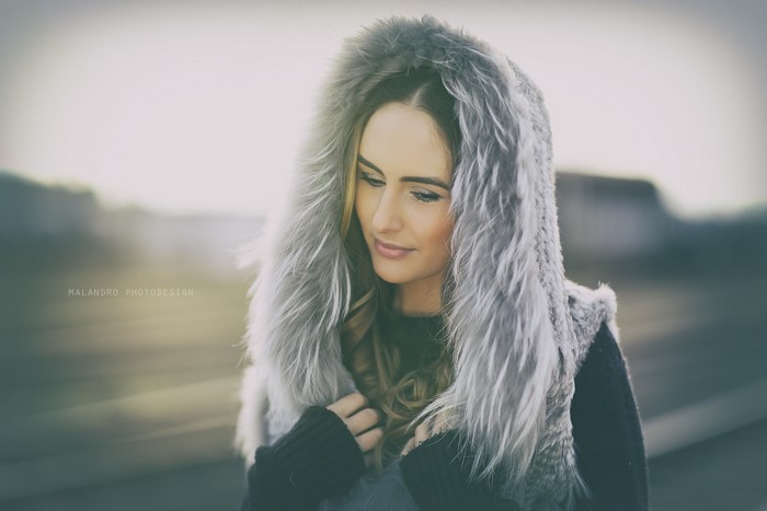 Woman wearing a fur-lined hood and black sweater