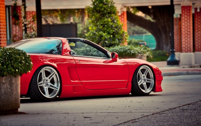 Red Honda NSX sports car with custom wheels