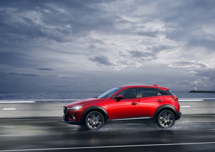 Red Mazda CX-3 Crossover Driving on Wet Road by Ocean