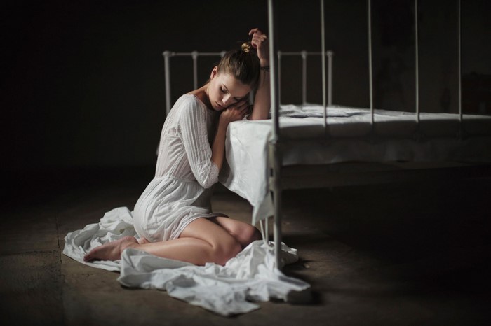 Woman in White Dress Kneeling Beside Bed