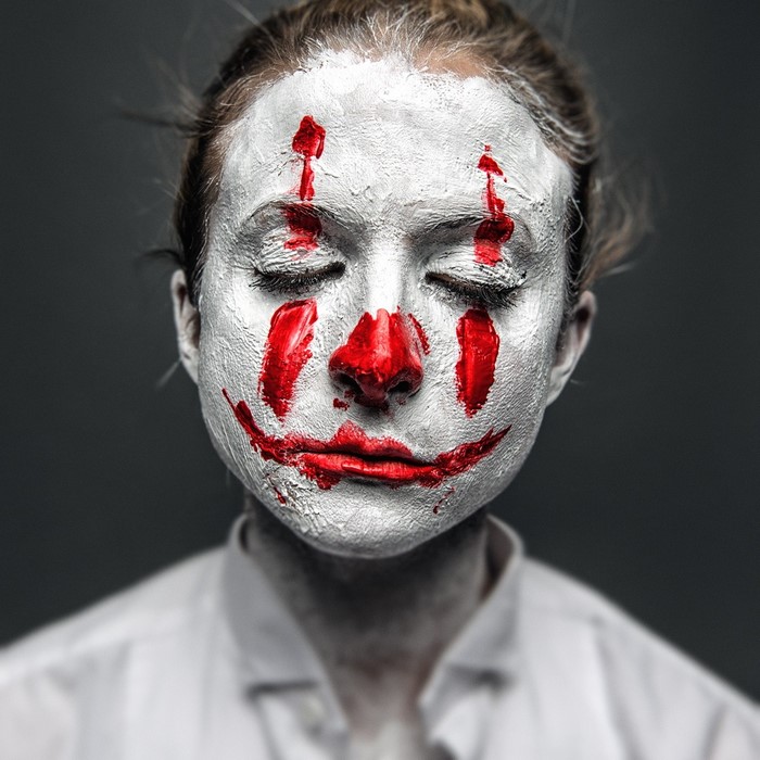 Woman with clown makeup and closed eyes