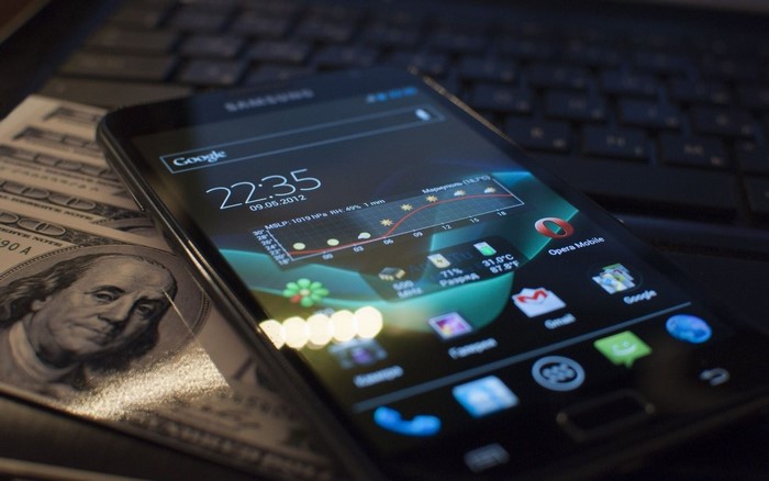 Samsung smartphone on laptop with US dollars