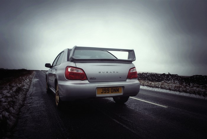 Silver Subaru Impreza WRX STI on a wet road
