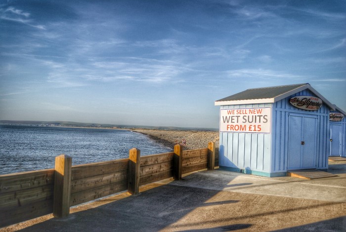 Beach huts selling wetsuits by the sea in England