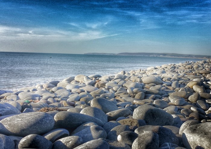 Pebble beach with ocean and blue sky