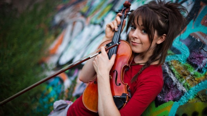 Woman holding a violin with graffiti background