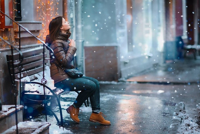 Woman sitting on a bench in the snow