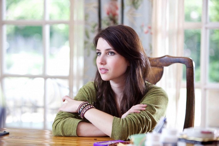 Emma Roberts sitting at a table