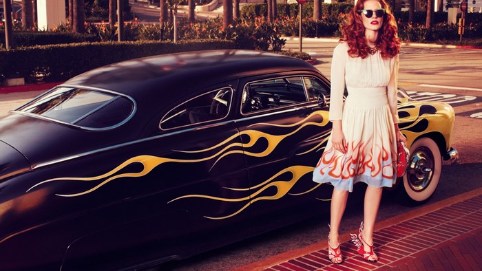 Woman with red hair and classic car with flames