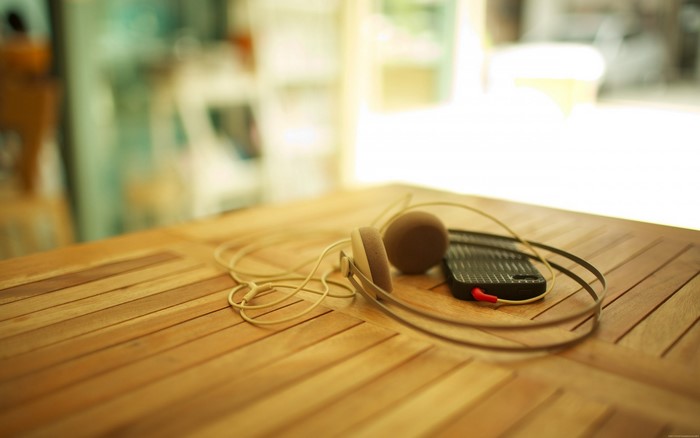 Headphones and smartphone on a wooden table
