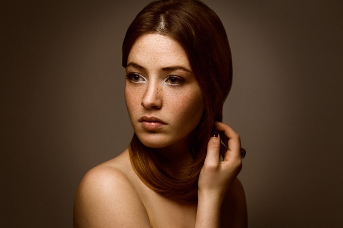 Portrait of a young woman with freckles and brown hair