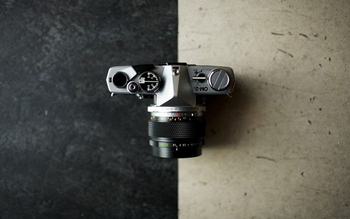 Olympus OM-2 camera with lens on textured surface