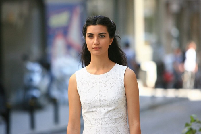 Tuba Büyüküstün in a white lace dress outdoors