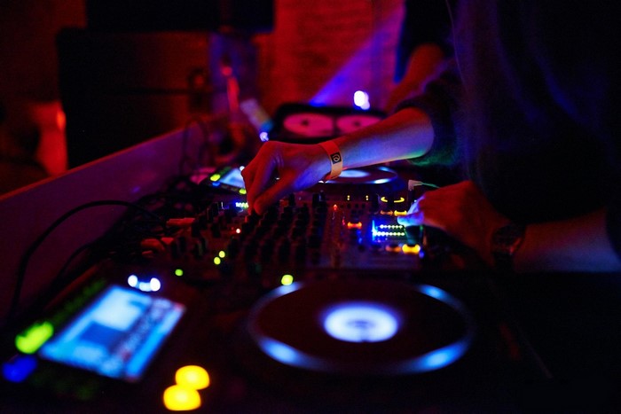 DJ performing with turntables and mixing console